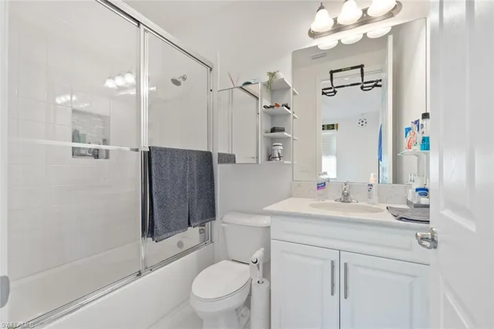 Full bathroom featuring vanity and shower / bath combination with glass door