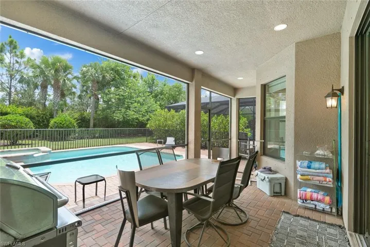 View of swimming pool featuring a fenced backyard, a pool with connected hot tub, a patio, and outdoor dining area