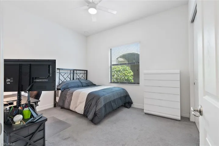 Carpeted bedroom with baseboards and ceiling fan
