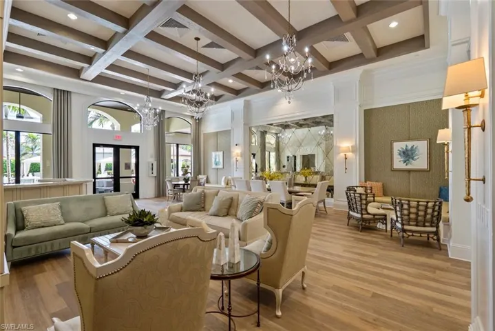 Building lobby featuring beam ceiling, coffered ceiling, wallpapered walls, recessed lighting, and a high ceiling