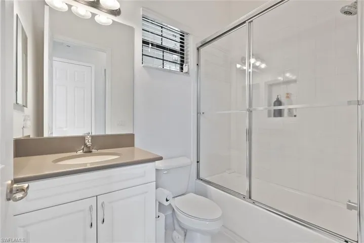 Full bath with vanity and bath / shower combo with glass door