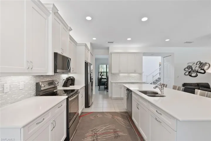 Kitchen with stainless steel appliances, backsplash, light countertops, and recessed lighting