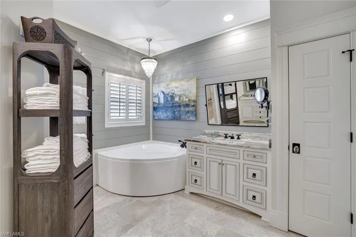 Full bathroom with a soaking tub, walk-in shower and two updated vanities.