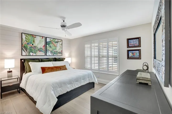 Bedroom with shiplap walls, nice light, custom closet system. Reclaimed wood floors.