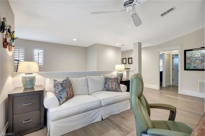 Den-Office with ample space for a sleeper sofa, plantation shutters on windows.