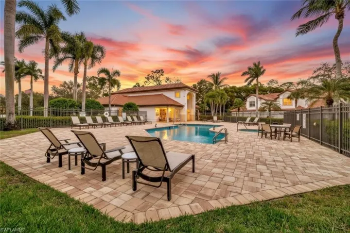 Pool at dusk with a patio area and a community pool