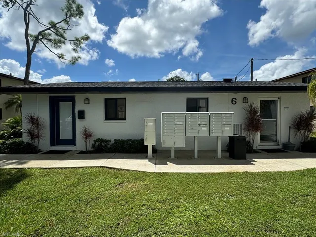Back of property featuring stucco siding and a lawn