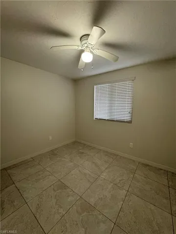 Empty room with a textured ceiling and ceiling fan