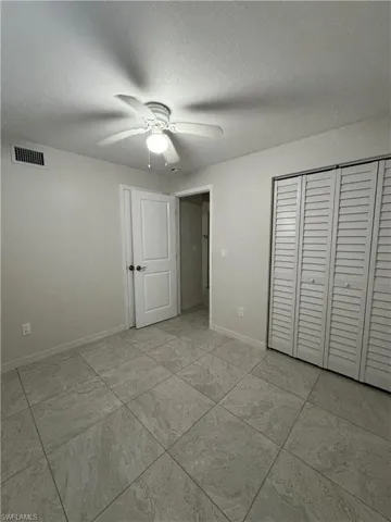 Unfurnished bedroom featuring a closet, a ceiling fan, and a textured ceiling