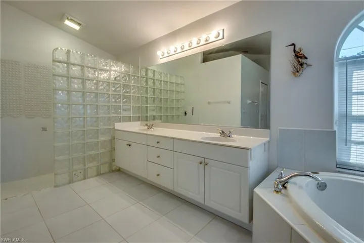 Bathroom with tile patterned flooring, vanity, and shower with separate bathtub