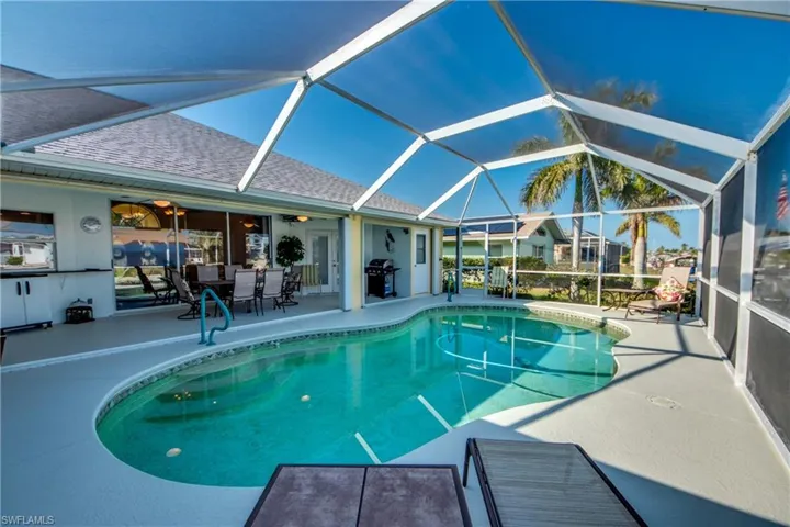 View of swimming pool featuring a lanai, area for grilling, and a patio area
