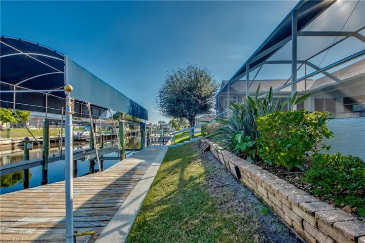 View of dock featuring a water view and glass enclosure