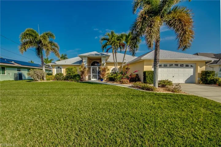 Ranch-style home featuring a garage, central AC, and a front lawn