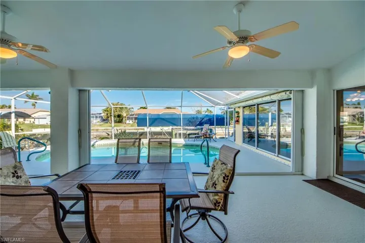 Sunroom with a pool and ceiling fan