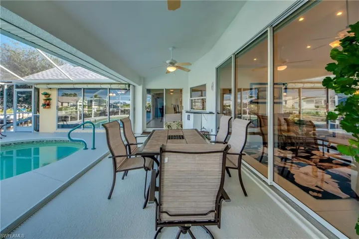 View of swimming pool featuring ceiling fan, a lanai, and a patio