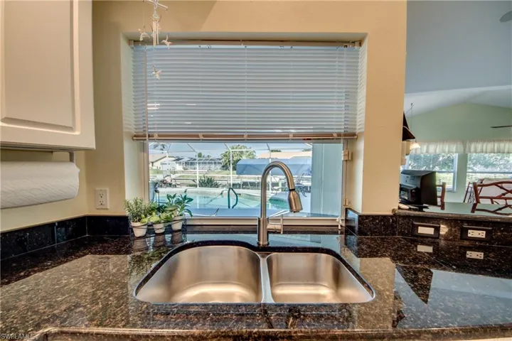 Details with dark stone countertops, sink, and white cabinets
