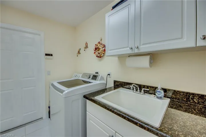 Washroom featuring cabinets, washing machine and dryer, and sink
