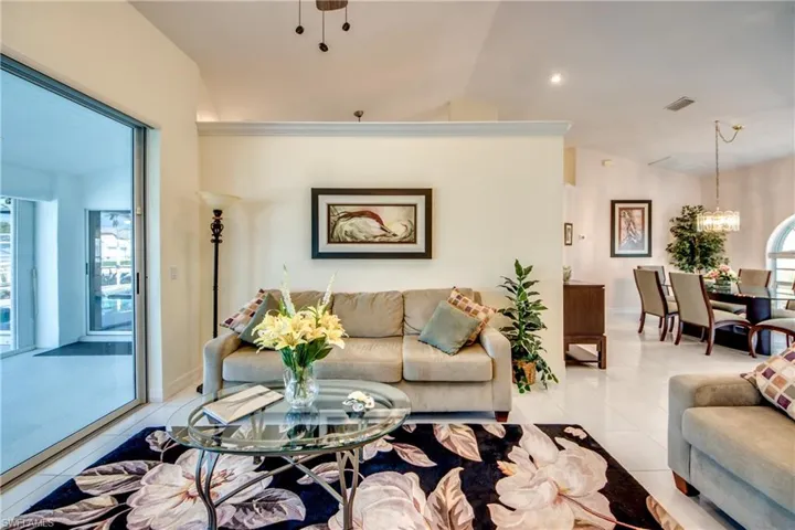 Tiled living room with lofted ceiling and a chandelier