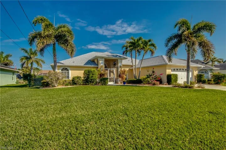 Ranch-style home with a garage and a front lawn