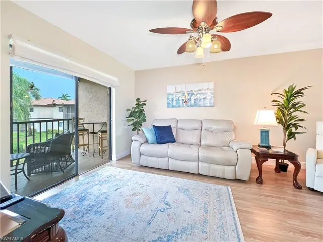 Living room with light wood-type flooring and ceiling fan