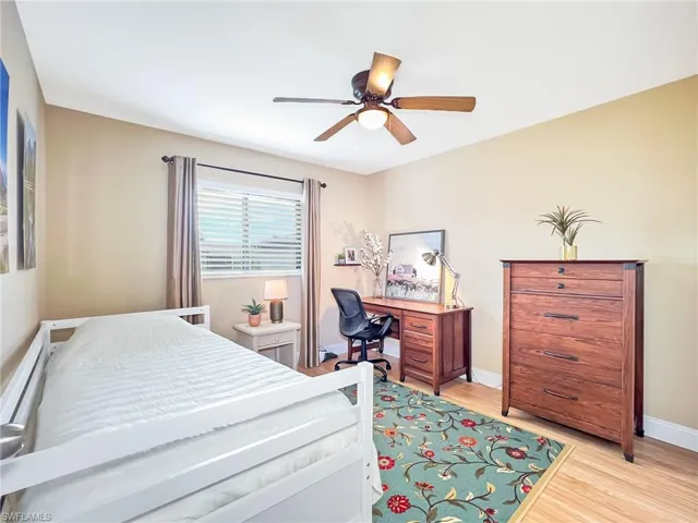 Bedroom with ceiling fan, light hardwood / wood-style floors, and a baseboard heating unit