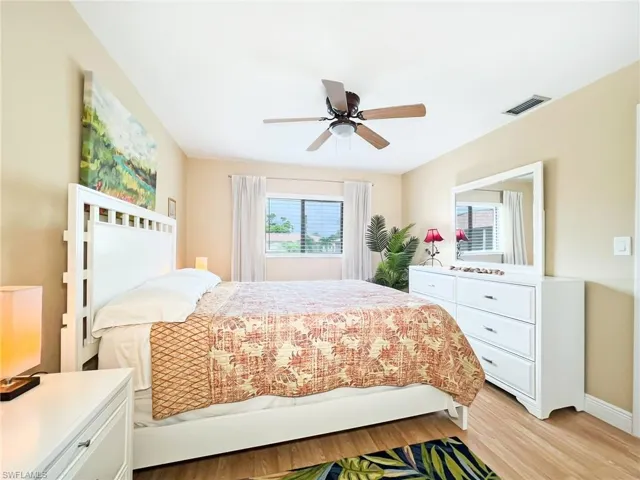 Bedroom with multiple windows, ceiling fan, and light hardwood / wood-style floors