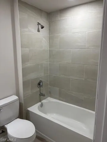 Bathroom featuring bathtub / shower combination and toilet