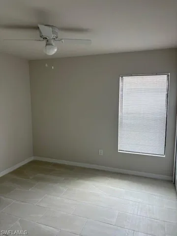 Spare room with a ceiling fan and baseboards
