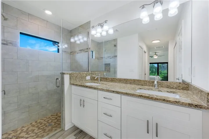 Ensuite primary bathroom with dual sinks, beautifully tiled walk in shower and so much storage.