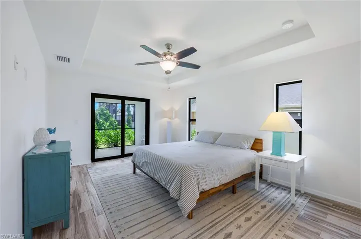 Primary bedroom with natural lighting, ceiling fan and direct lanai access.