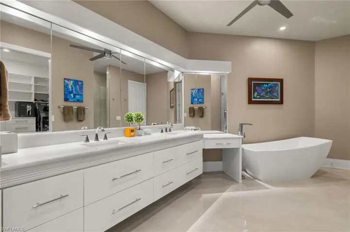 Bathroom featuring tile patterned flooring, shower with separate bathtub, vanity, and ceiling fan