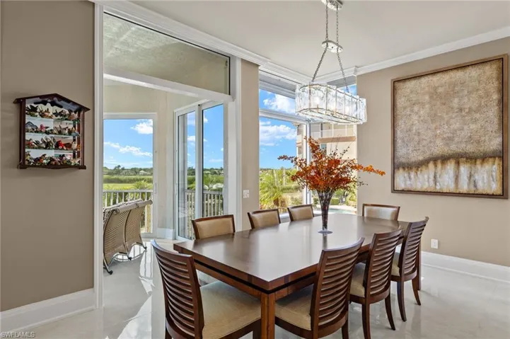 Dining space with light tile patterned flooring, an inviting chandelier, and ornamental molding