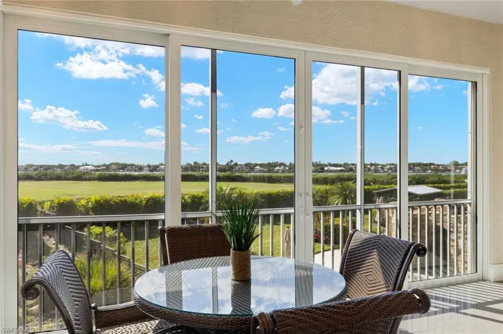 Sunroom / solarium featuring view of the bay and golf course