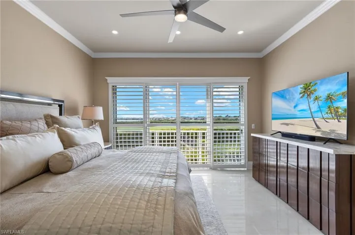 Bedroom with ornamental molding, multiple windows, ceiling fan, and access to exterior