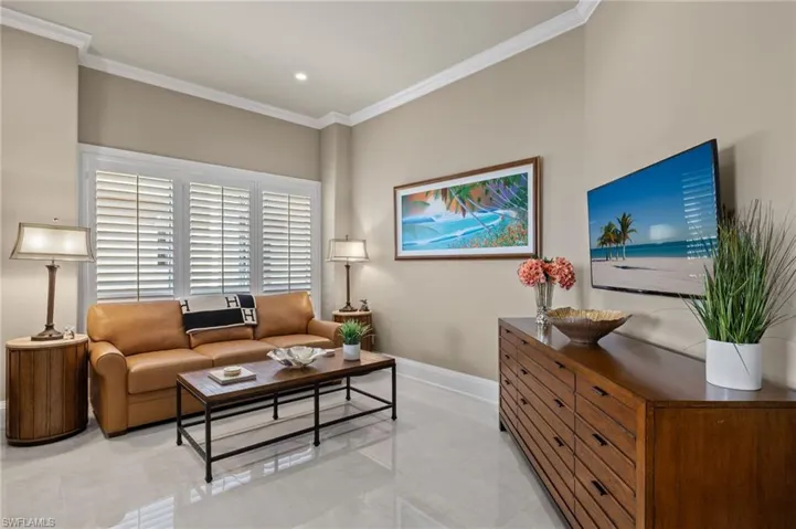 Living room featuring ornamental molding and light tile patterned floors