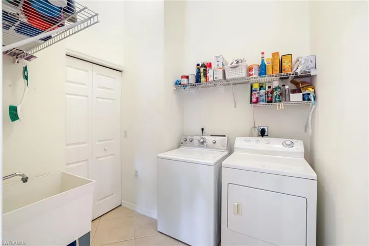 Laundry area with light tile patterned floors and independent washer and dryer