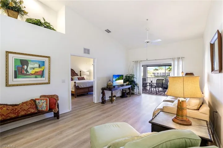 Living room with wood finished floors, lofted ceiling, and ceiling fan