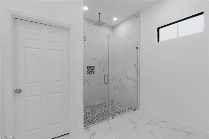Bathroom featuring marble finish floors, a marble finish shower, and recessed lighting