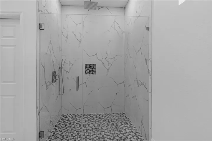 Full bath featuring a marble finish shower