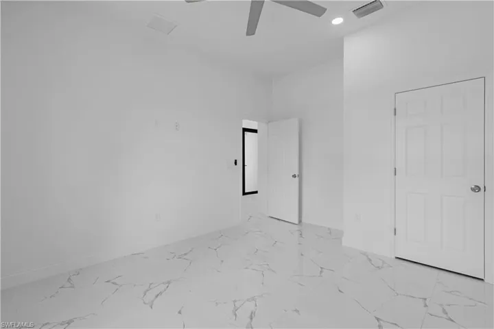 Unfurnished bedroom featuring light marble finish floors, ceiling fan, and recessed lighting