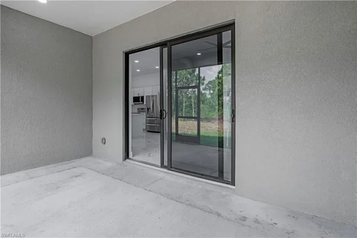 Property entrance featuring stucco siding and a patio
