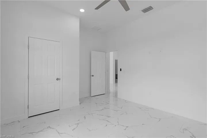 Unfurnished bedroom with ceiling fan, light marble finish flooring, and recessed lighting