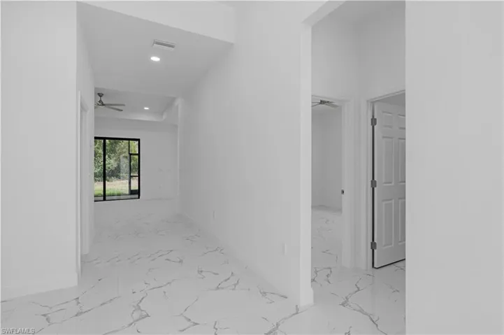 Hall featuring recessed lighting and light marble finish flooring