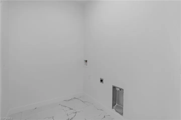 Laundry room featuring light marble finish flooring, hookup for a washing machine, and hookup for an electric dryer