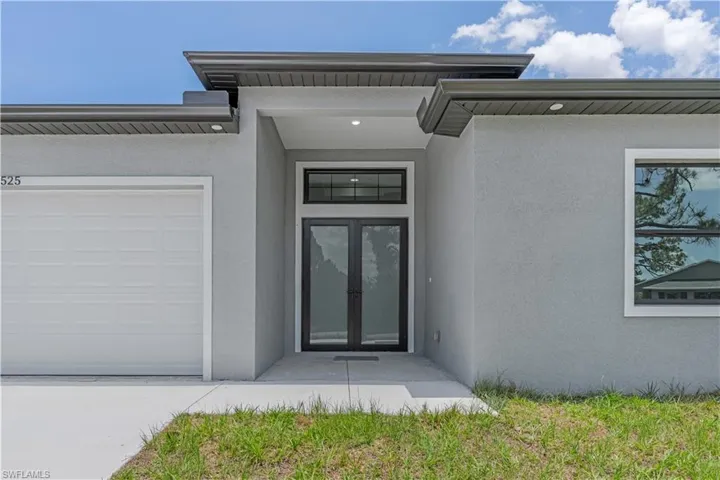 Property entrance with stucco siding and a garage