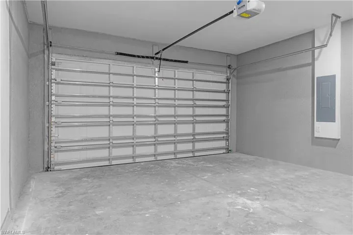 Garage featuring electric panel and a garage door opener