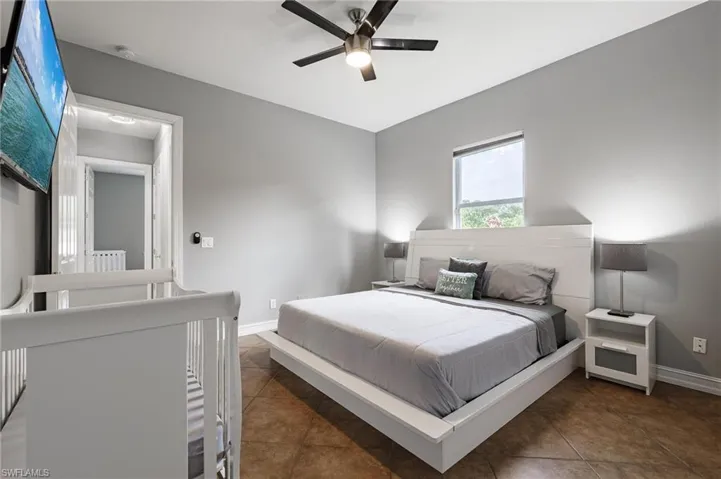 Bedroom with ceiling fan and tile patterned floors