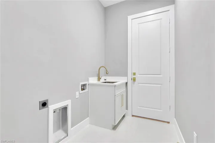 Laundry room with electric dryer hookup, hookup for a washing machine, cabinet space, and light tile patterned floors