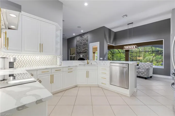 Kitchen featuring light stone counters, dishwasher, decorative light fixtures, white cabinetry, and light tile patterned floors