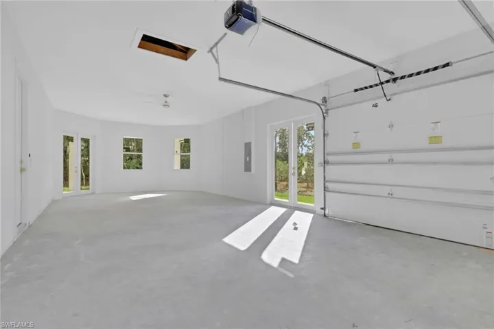 Garage with french doors, a garage door opener, and electric panel